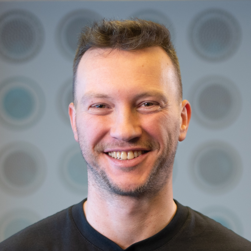 Ein lächelnder Mann mit Bart.