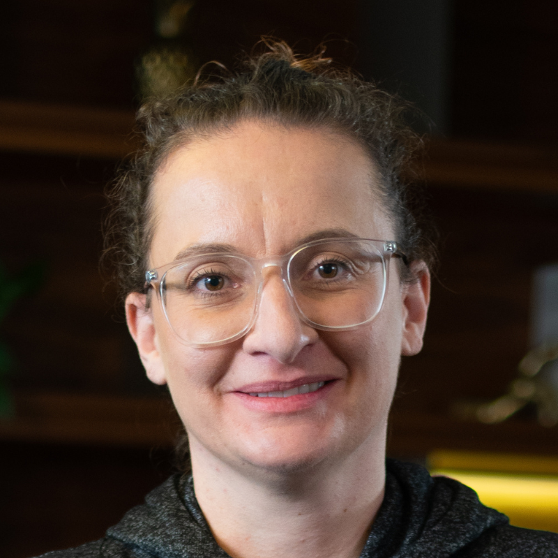 Eine lächelnde Frau mit Brille.