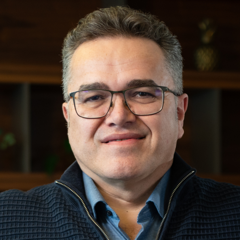 Ein lächelnder Mann mit Brille.